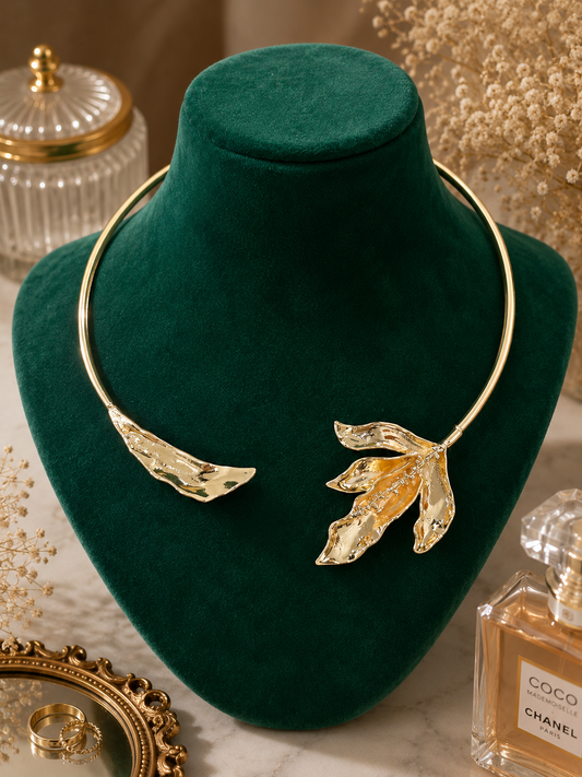 Aurora Gold Leaf Statement Necklace displayed on a jewelry bust showcasing its polished gold leaf-inspired statement design.