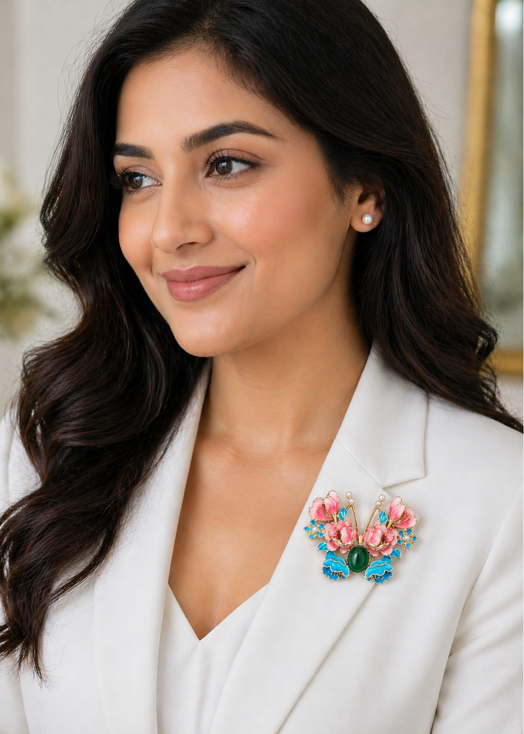 Woman wearing a white blazer with a colorful butterfly brooch