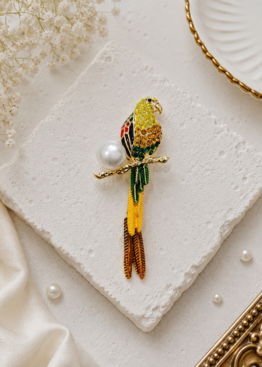 Golden Parrot Pearl Brooch displayed in a light studio flat lay