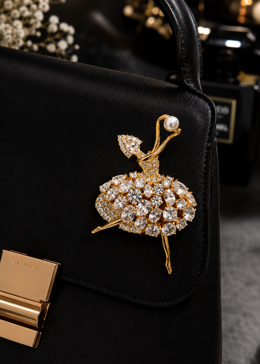 Pearl Pirouette Crystal Dancer Brooch styled on a structured black handbag