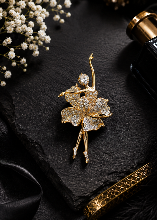 Golden Bloom Ballerina Brooch displayed in a dark studio flat lay