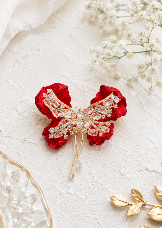 Crimson Bow Butterfly Brooch displayed in a light studio flat lay