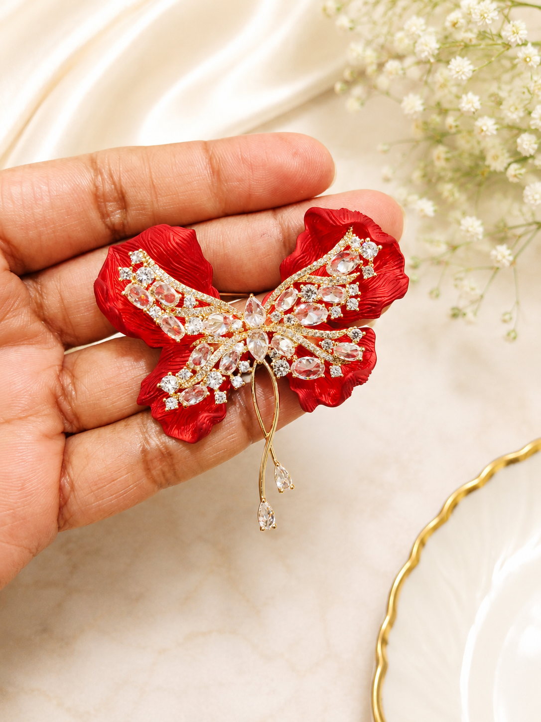 Crimson Bow Butterfly Brooch shown close up in hand