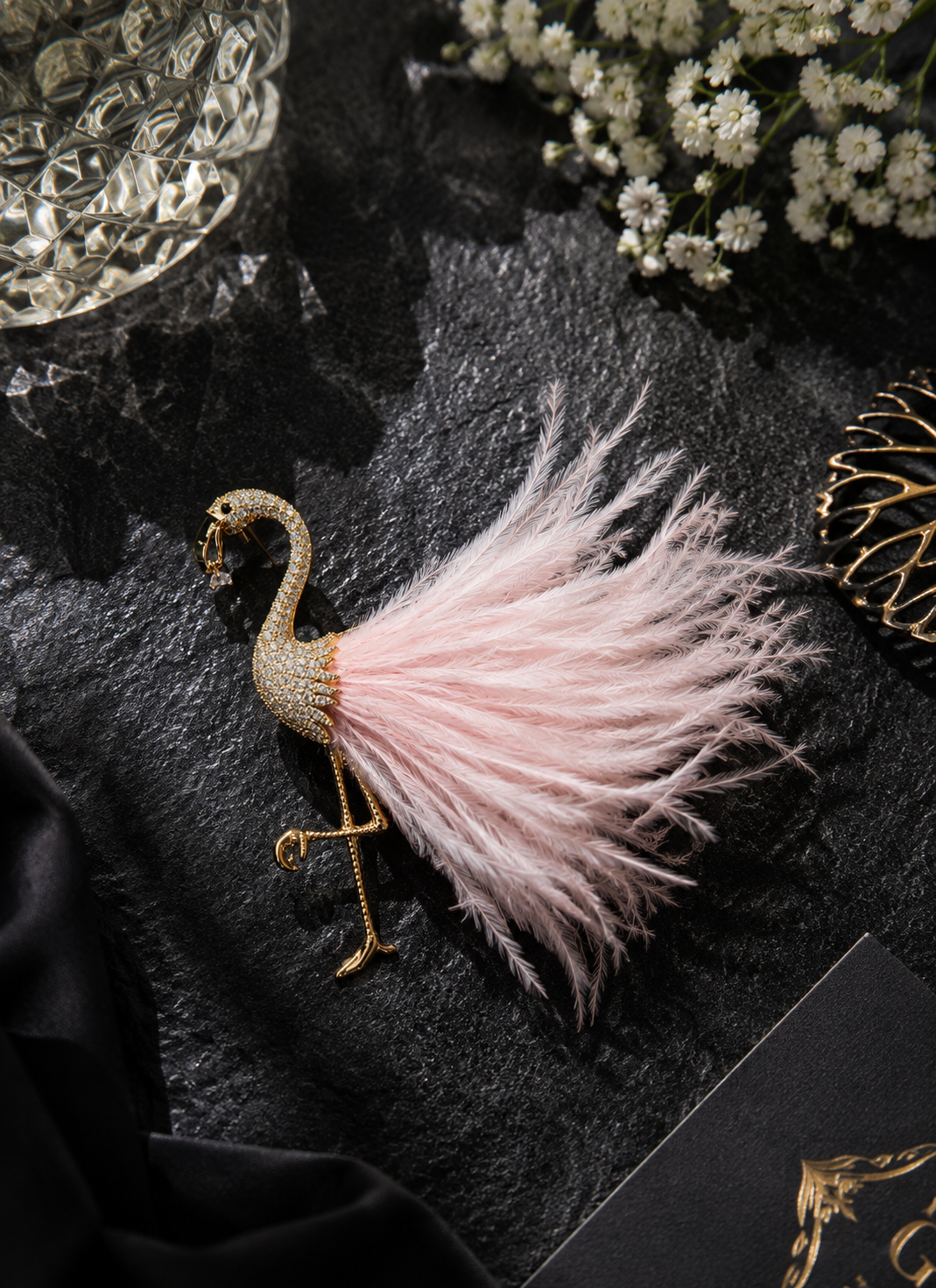 Blush Plume Flamingo Brooch displayed in a dark studio flat lay