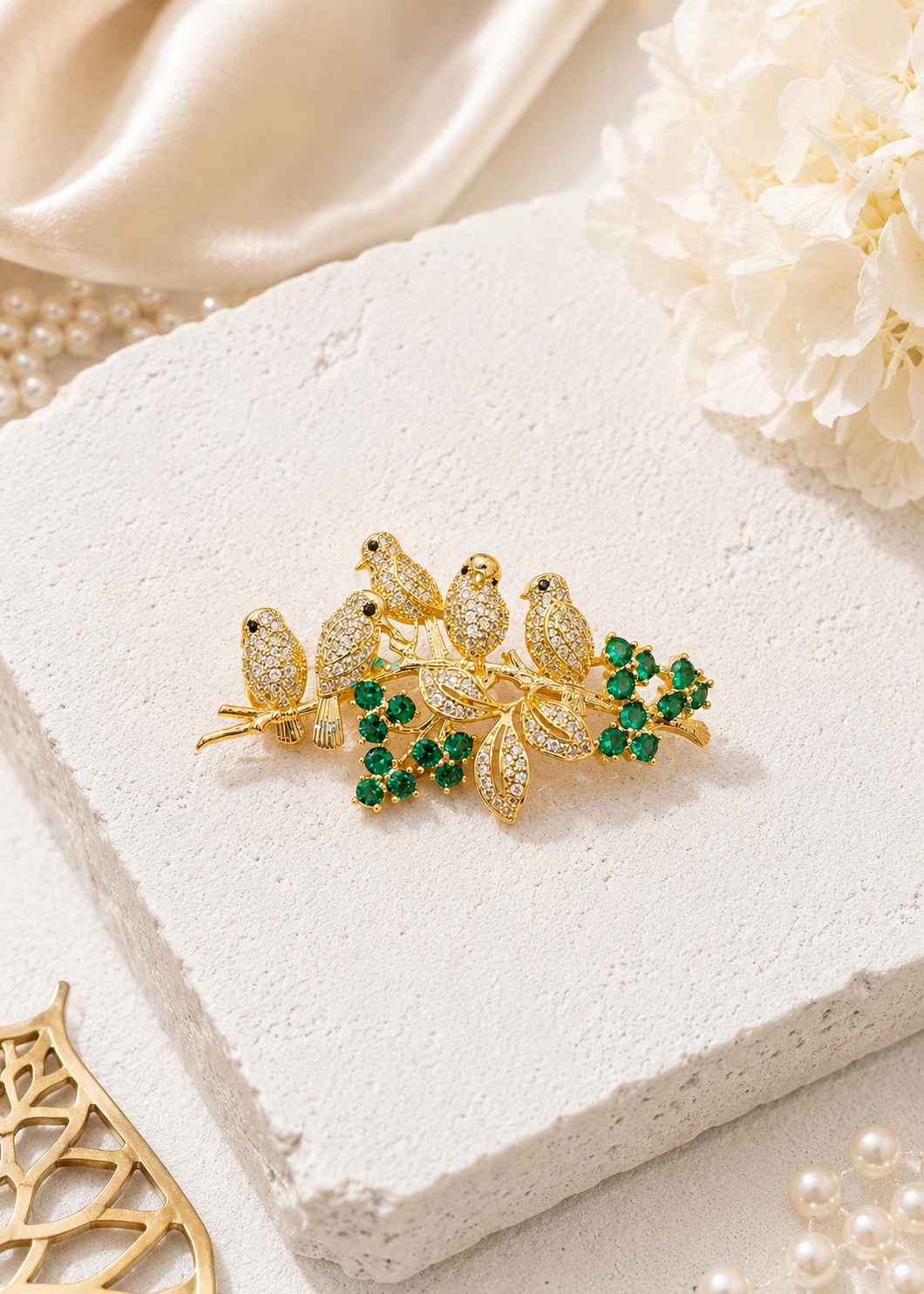 Emerald Songbird Floral Brooch displayed in a light studio flat lay