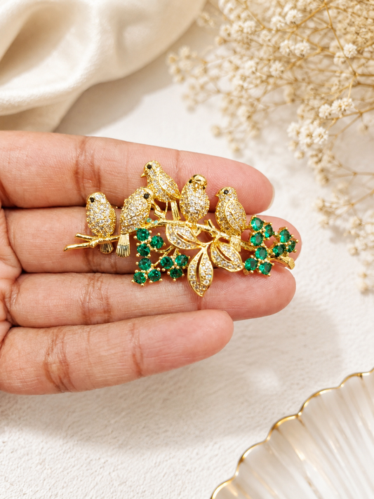 Emerald Songbird Floral Brooch shown close up in hand