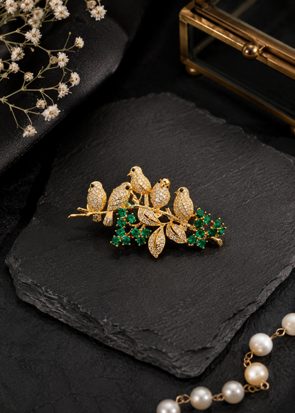 Emerald Songbird Floral Brooch displayed in a dark studio flat lay