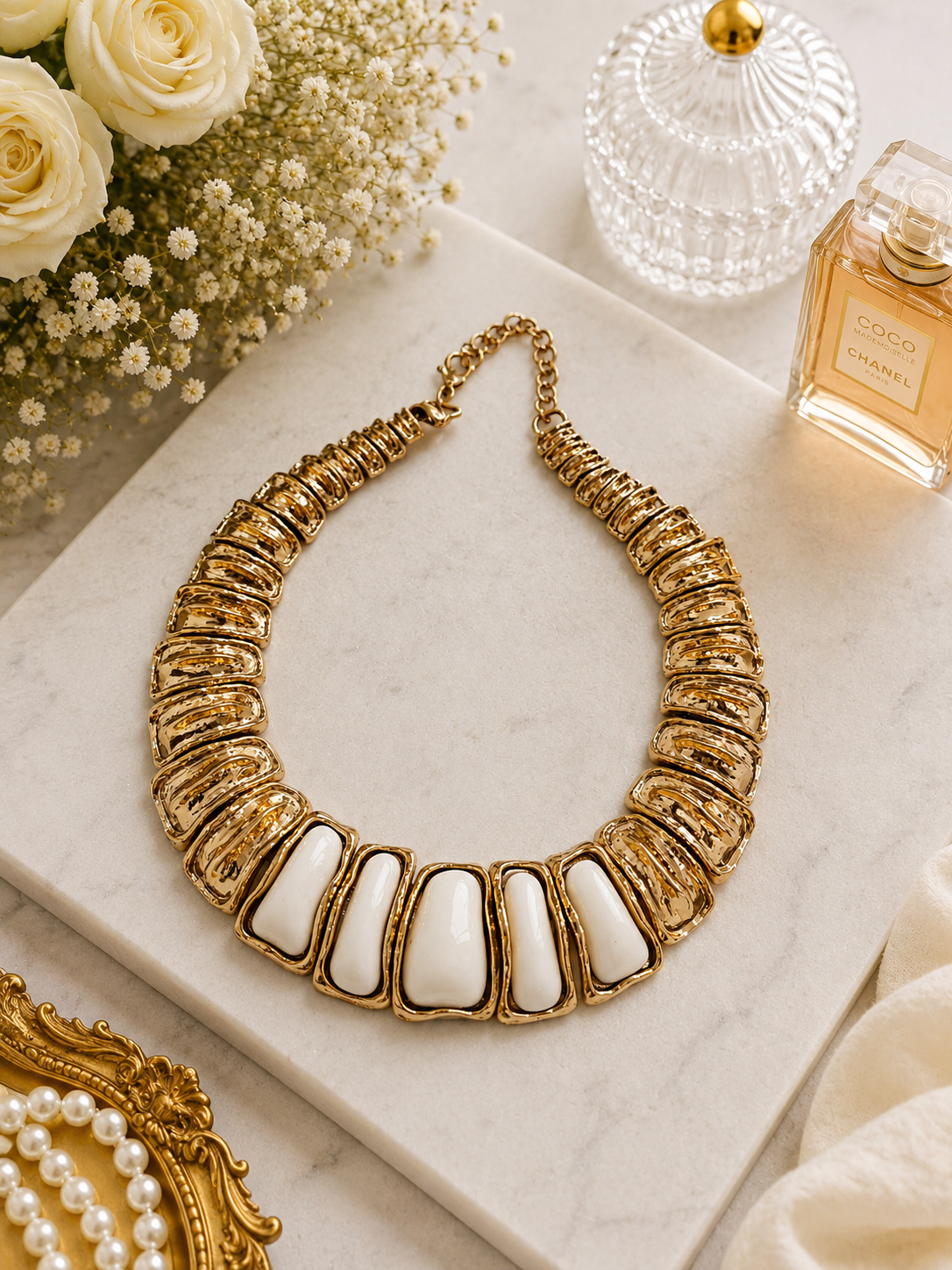 Ivory Crest Enamel Necklace shown in a styled flat lay