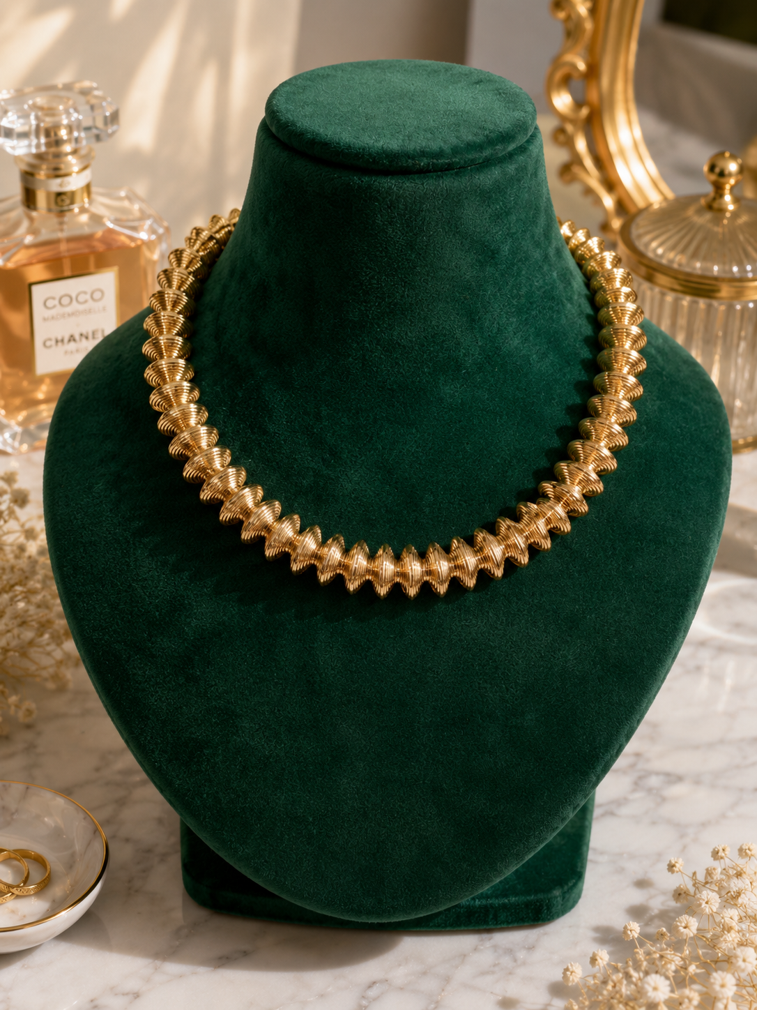 Golden Laurel Statement Necklace displayed on a green jewellery bust