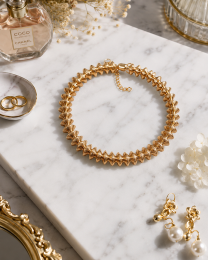 Golden Laurel Statement Necklace shown in a styled flat lay