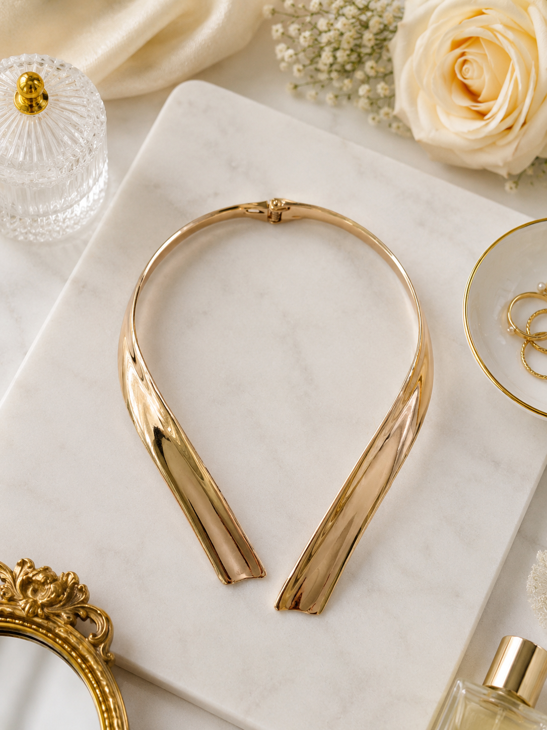Golden Arc Collar Necklace shown in a styled flat lay