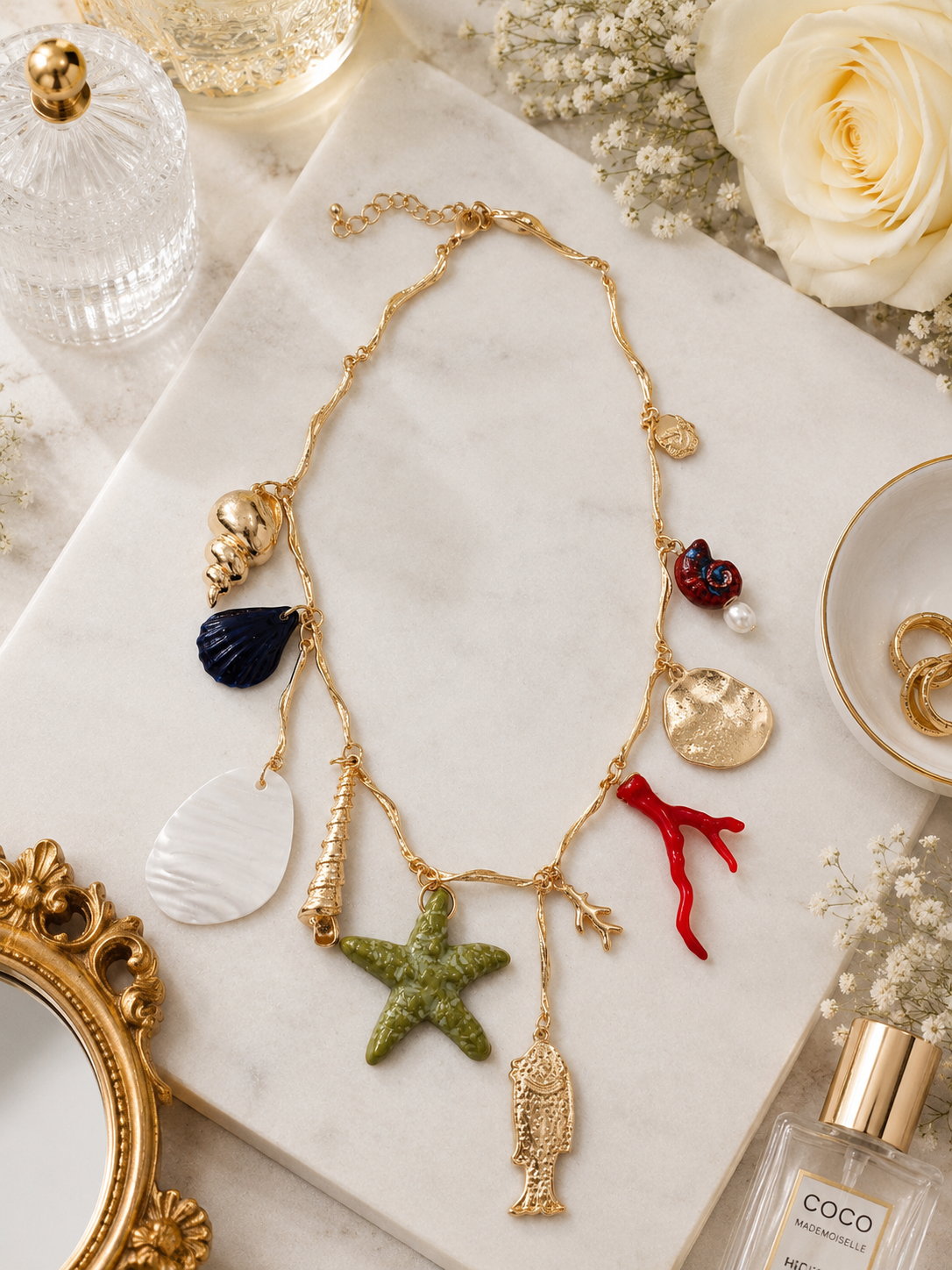 Coastal Treasure Charm Necklace shown in a styled flat lay