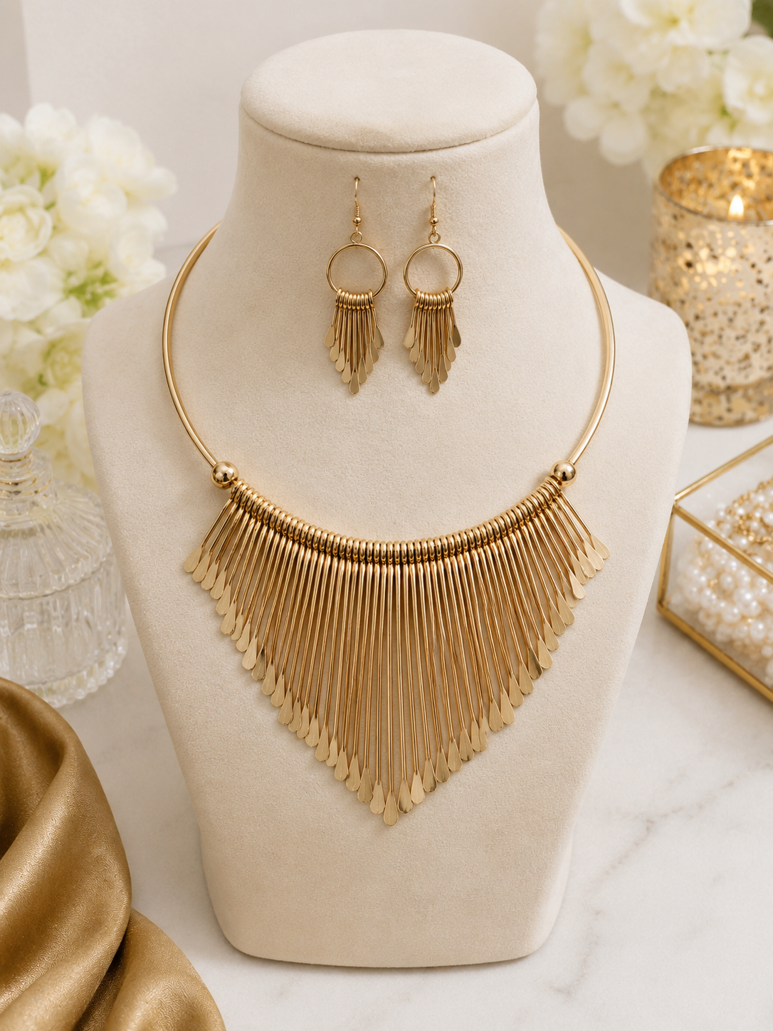 Aurora Gold Statement Necklace Set displayed on jewellery bust with matching gold fringe earrings
