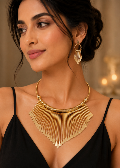 Model wearing Aurora Gold Statement Necklace Set with matching gold fringe earrings in black dress