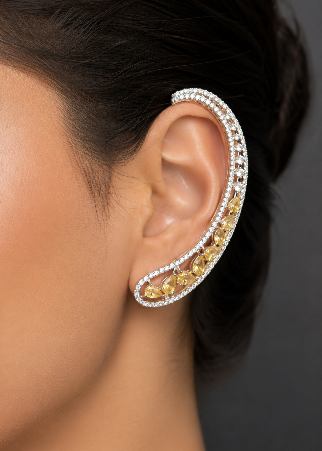 Close-up of Celeste Yellow Stone Ear Cuff with sparkling yellow stones and silver-tone finish