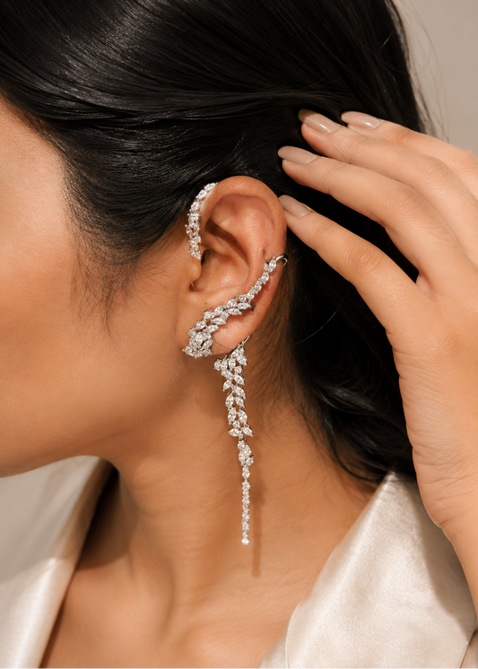 Woman wearing Celestia Cascade silver crystal statement ear cuffs with elegant cascading leaf design.