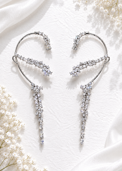 Silver crystal cascading statement ear cuffs with marquise cubic zirconia stones displayed on a white textured background.