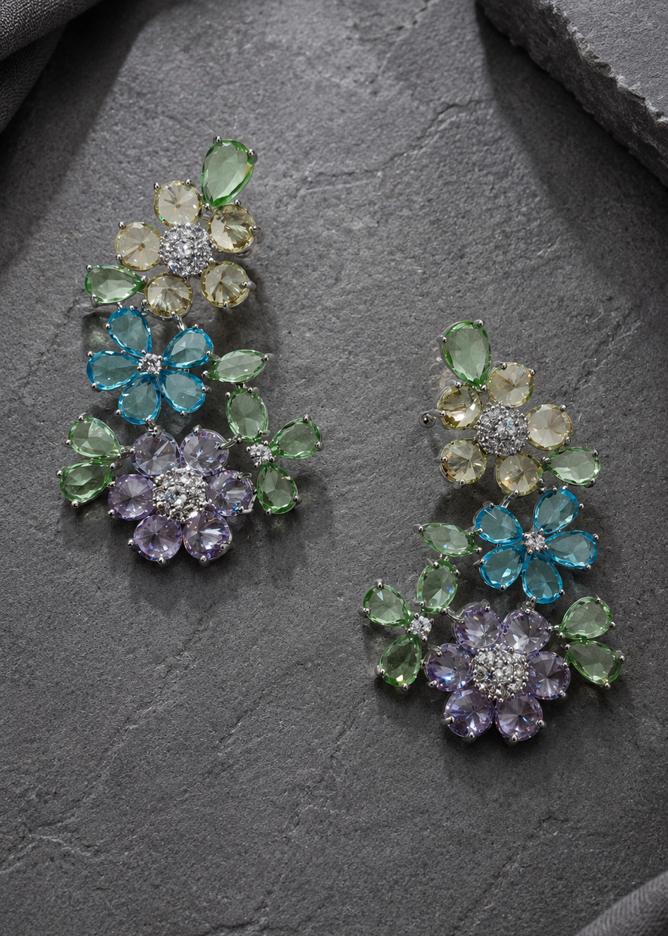 Premium multicolor floral statement ear cuffs with pastel crystals and rhodium finish displayed on grey stone background