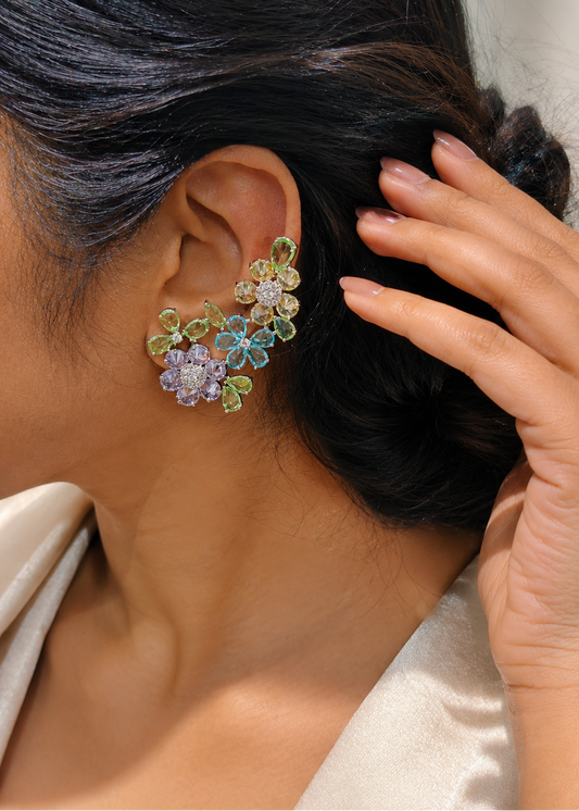Woman wearing Fleuré Pastel multicolor floral statement ear cuffs with pastel crystal stones and rhodium finish