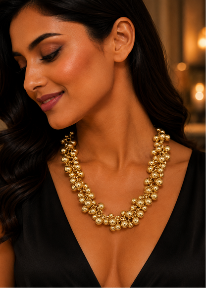 Model wearing Gold Bead Statement Necklace featuring clustered gold-tone beads and elegant statement styling