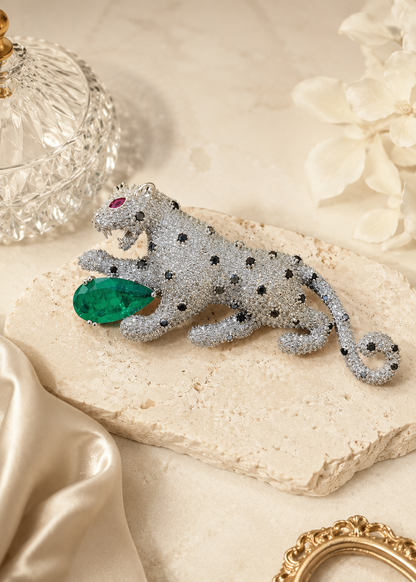 Regal Green Panther Brooch featuring crystal detailing, black stone accents, and a green gemstone centerpiece on a black slate display