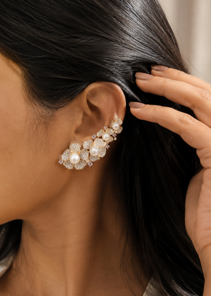 Model wearing Rosalie Pearl Ear Cuff Set featuring floral cubic zirconia petals with elegant pearl accents in a gold finish.