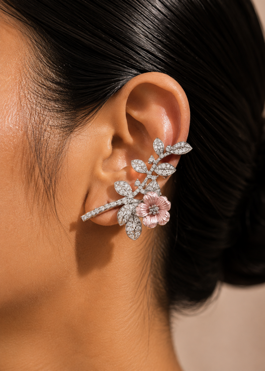 Close-up of woman wearing silver floral ear cuff with blush pink flower and sparkling crystal leaves.