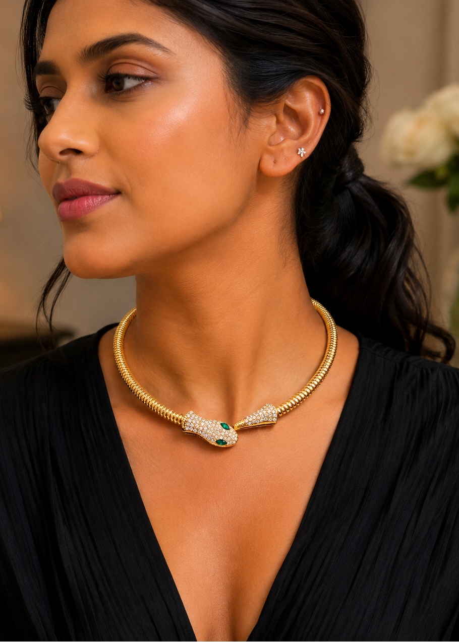 Model wearing Serpentine Green Crystal Necklace featuring luxurious gold snake design with sparkling crystals and emerald green eyes.